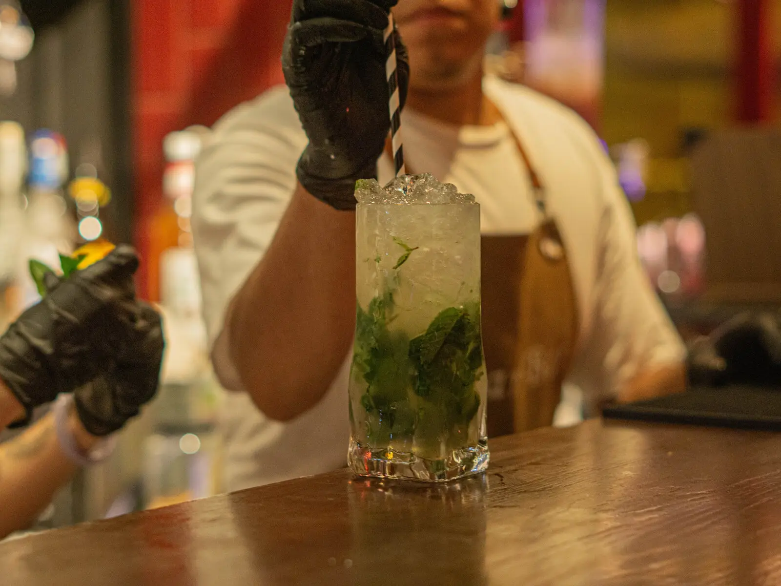Bartender de STARS BAR sirviendo un mojito en la barra
