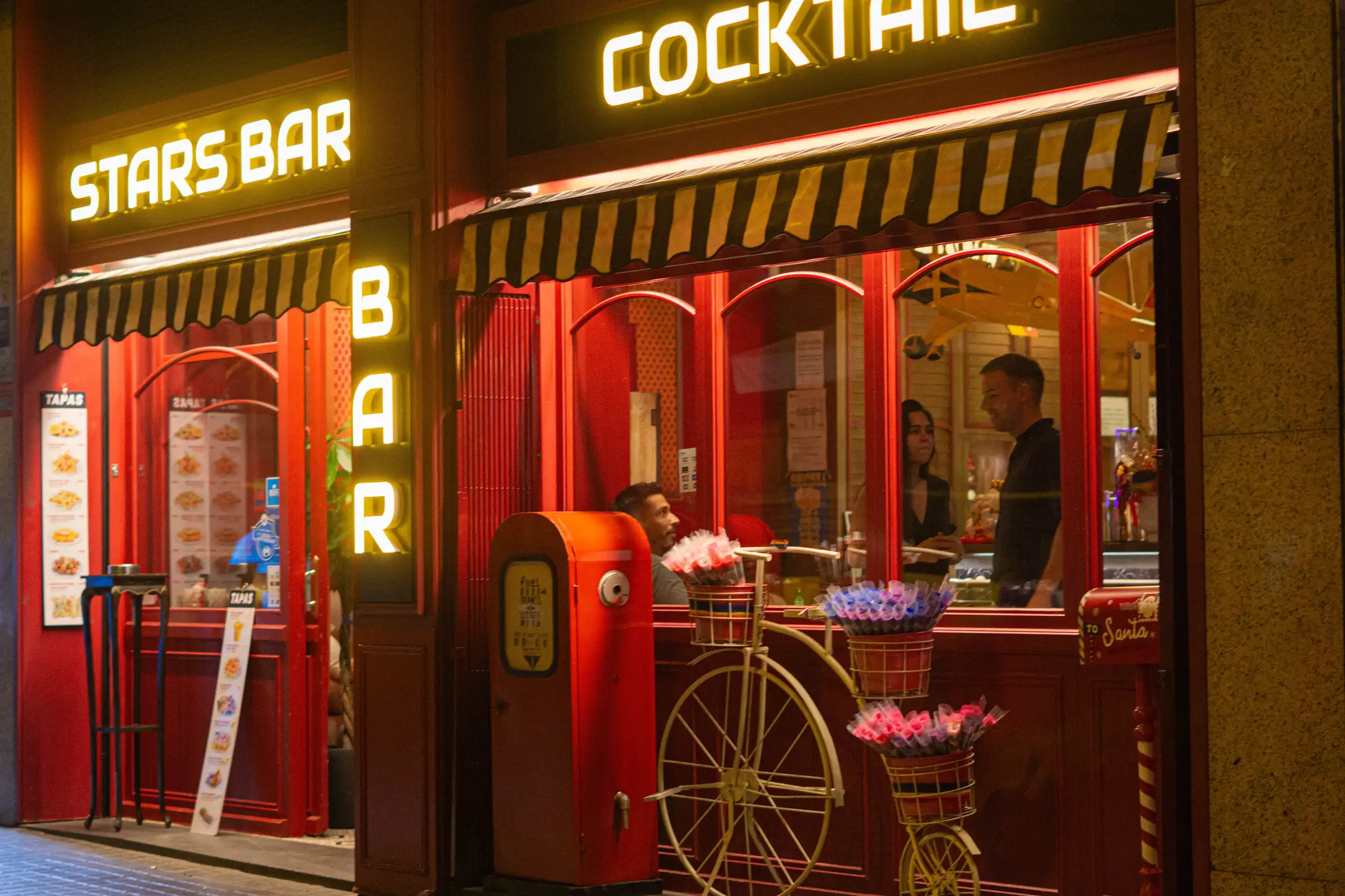 Fachada de STARS BAR de noche con sus rótulos de neón en el Eixample